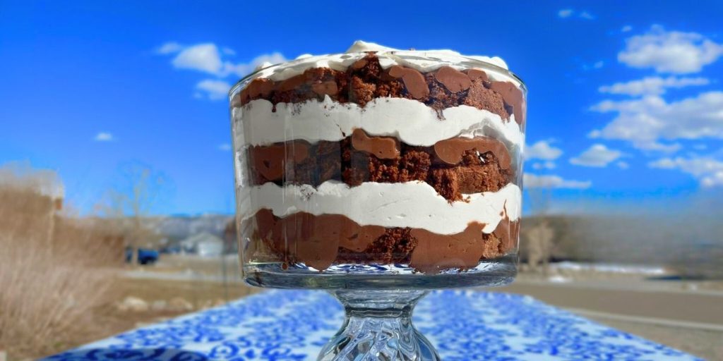 chocolate brownie heath bar trifle in a trifle dish sitting on table outside