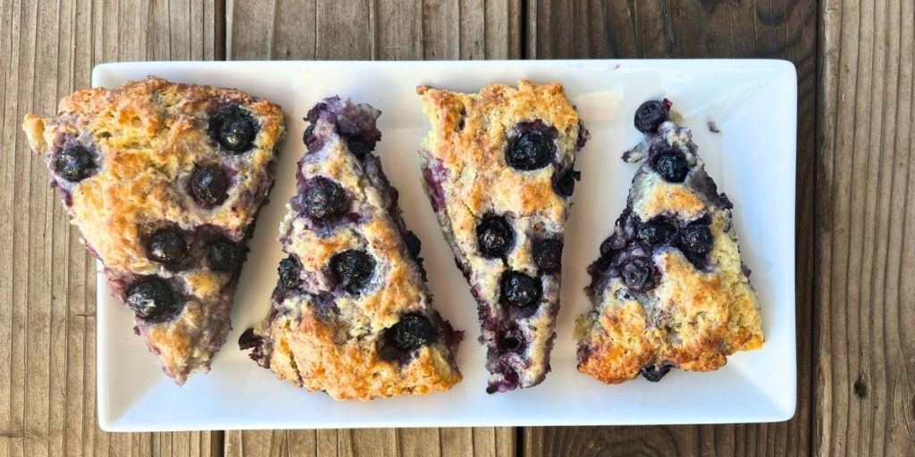 4 high altitude blueberry scones on a white serving platter