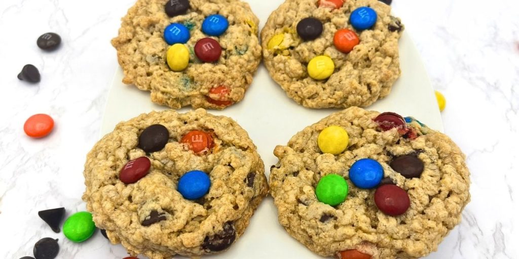 4 high altitude monster cookies with M&M's on a white plate