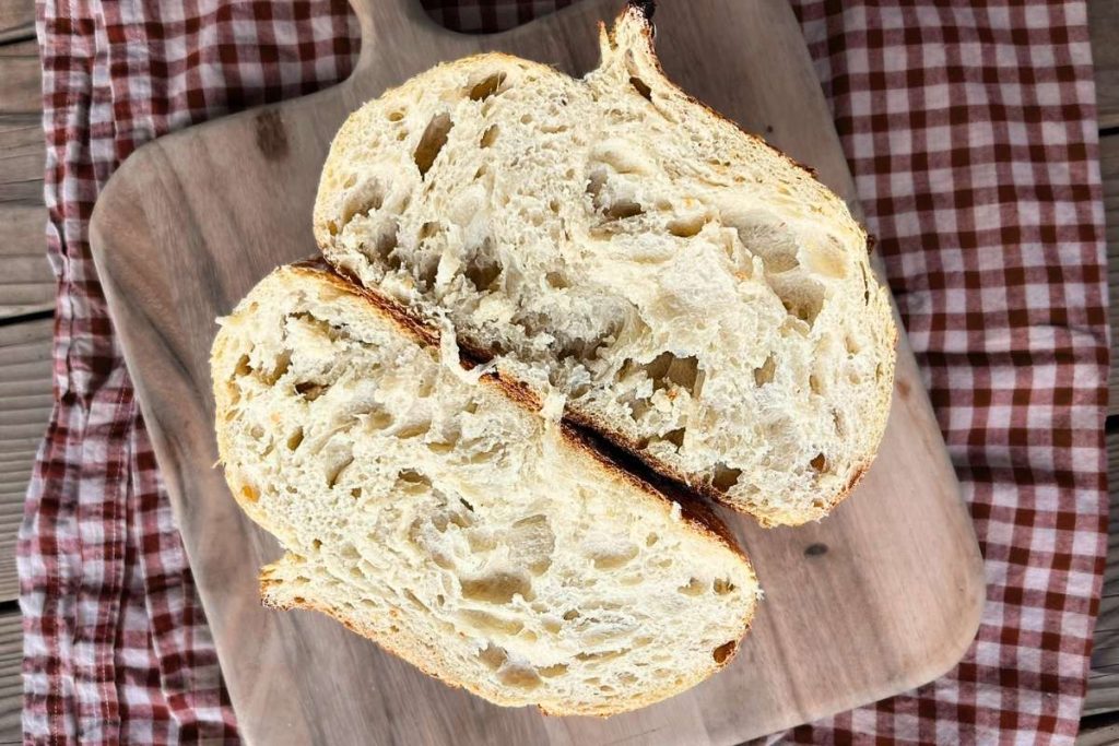 a loaf of high altitude sourdough cut in half with beautiful airy inside