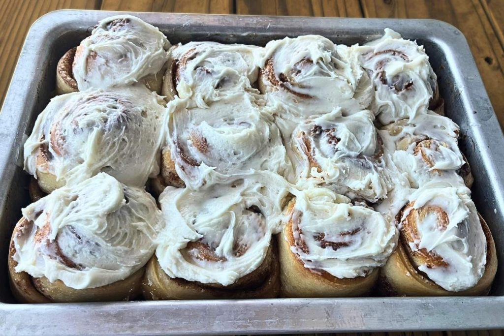 a 9x13 pan of high altitude sourdough cinnamon rolls with vanilla frosting