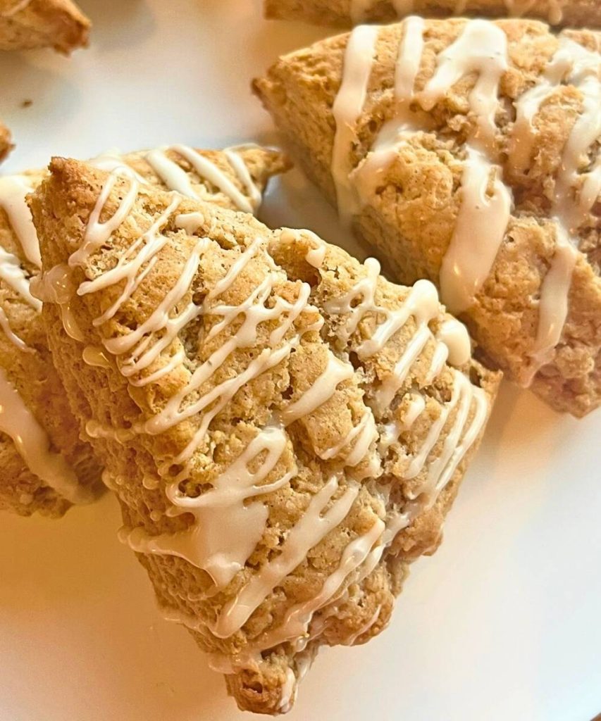 cinnamon roll scones drizzled with vanilla icing on a plate