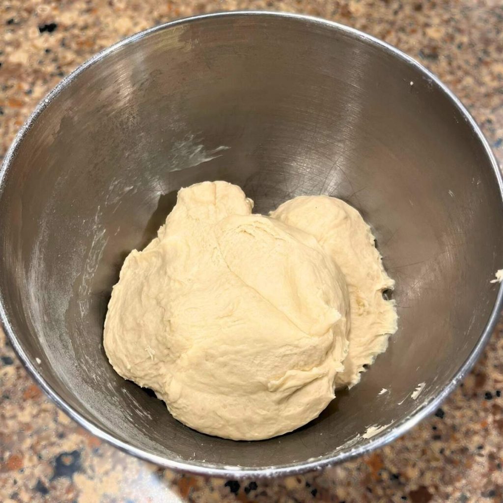 a mixing bowl filled with sourdough English muffin dough